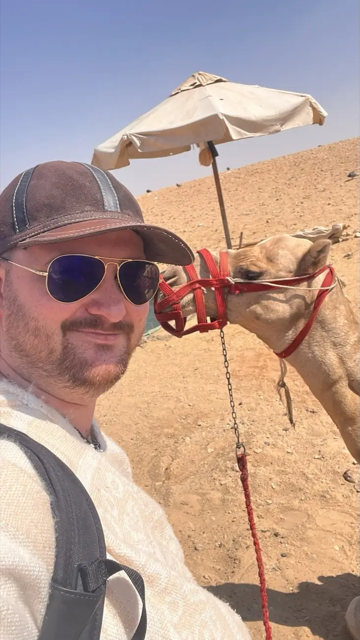 Jonas mit einem Kamel an den Pyramiden